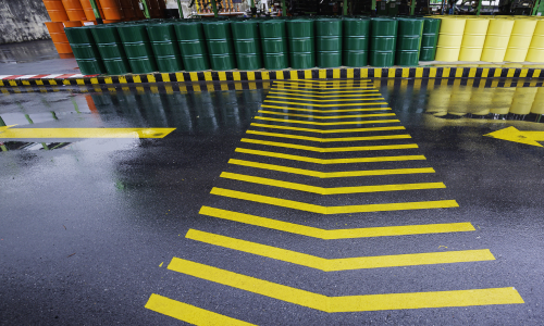 Pista de corrida demarcada com tinta para demarcação viária e barris coloridos ao fundo